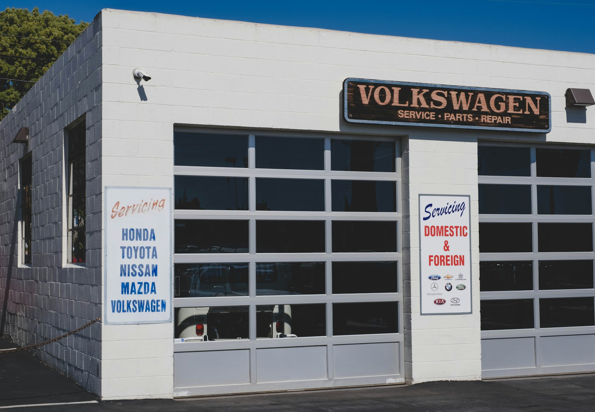 An auto repair shop with signs detailing which makes they serve, both foreign and domestic.