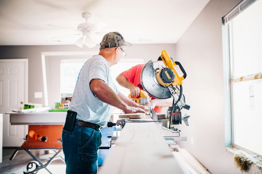 A handyman works inside a home.